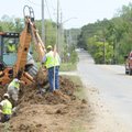 A pickup travels east on Cato Springs Road in Fayetteville as workers with Dean Crowder Construction...