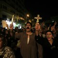 In this Tuesday, Oct. 4, 2011 file photo, Egyptian Copts hold Christian crosses and chant slogans as...