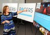 Melissa Thoma speaks at a media luncheon Tuesday at the Rogers-Lowell Chamber of Commerce about the features she and her husband Martin Thoma incorporated into the new logo for the Rogers. The firm of ThomaThoma began working on the logo and its tagline “Rogers, Arkansas — Where Possible Lives” in early March.