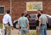 Law enforcement officers gather Wednesday morning outside the Phillips County sheriff’s office in Helena-West Helena, where things were quieter after Tuesday’s drug-trafficking raids. 