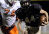 Parker Hancock, right, Bentonville Gold running back, races past Springdale Southwest’s Kaleb Wade on his way to a first quarter touchdown Thursday during the Tigers’ game against the Cougars at Tiger Stadium in Bentonville. Parker had two touchdowns in the game.
