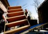 Two Men and a Truck employees Andrew Brown (left) and Jeff Landsaw load shelving into the truck while moving the possessions of Dave and Jacki Hudak in Fayetteville on Oct. 12. 