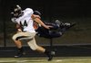 Bentonville Gold’s Parker Hancock, 44, nears the endzone as Rogers Heritage’s Joey Saucer uses his airborne momentum to try and pull Hancock down Thursday at Gates Stadium in Rogers.
