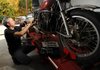 Clint Stephenson of Fayetteville works Wednesday on a Kawasaki KZ400 motorcycle for a customer at Adventure Motorsports Cooperative in Fayetteville. The cooperative pairs a mechanic with owners of motorcycles, scooters, all-terrain vehicles or any other small vehicle to guide them through its repair or restoration.
