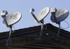 Dish Network satellite dishes crowd an apartment roof in February in Palo Alto, Calif. 