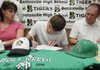 Zach McKnight signs to play baseball at University of Arkansas at Monticello while his parents, Robert McKnight, right, and Debbie McKnight, left, watch during a ceremony Wednesday at the Tiger Athletic Complex in Bentonville.