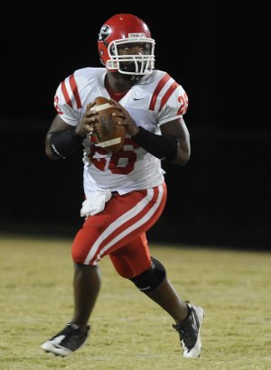 Deon Clay, Farmington’s senior quarterback, rolls out looking to pass in a game played earlier this season. Farmington will host Dumas in the first round of the Class 4A state playoffs Friday night at Allen Holland Field.