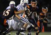 Rogers quarterback Nick Wary is wrapped up by Rogers Heritage lineback Branden Uhrig on a keeper during the Mounties’ game Sept. 30 against the War Eagles at Gates Stadium in Rogers.
