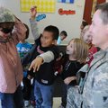 Private Benjamin Myers with the Arkansas National Guard lets Jack Baldwin, left, try on his helmet a...