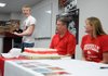 IN THE SWIM Dexter Thomas, Springdale High senior swimmer, left, thanks his father, Richard Thomas and mother Tami Thomas, coaches and friends before he signs a letter of intent to swim for the University of Louisville on Friday at Springdale’s fieldhouse. Thomas was also joined at the table by his sister Makenzie Thomas (not pictured) who is a junior at Springdale High.
