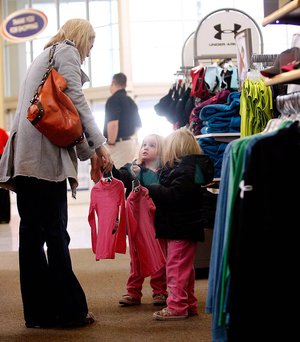 Ashley Miller of Cave Springs shops with her 3-year-old daughters, Kenzie and Katie, last week at Academy Sports & Outdoors in Rogers. 