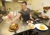 Gabriela Soto collects food Friday onto a serving tray before bringing it out to a patron at El Sol, a Mexican restaurant in Fayetteville.
