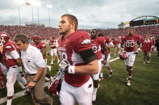 Arkansas tight end Garrett Uekman runs on the field with team mates Saturday, Nov. 19, at War Memorial Stadium in Little Rock. 
