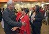 Former University of Arkansas basketball coach Nolan Richardson is greeted by UA employees Felicia Saine (center) and Katy Evans during a reception Monday for Richardson at the UA Multicultural Center in Fayetteville. Richardson was one of four recipients of the 2011 Silas Hunt Legacy Award which recognizes black Americans for their achievements or contributions.
