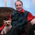 Brian Crane, an HIV survivor who was diagnosed in 1999, sits with his dog, Tootsie, on Nov. 22 at hi...