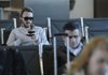 Matt James texts his girlfriend Wednesday while waiting for a flight at Northwest Arkansas Regional Airport in Highfill. James was on his way home to California.
