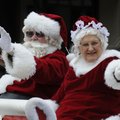 Santa and Mrs. Claus wave Saturday to the crowd during the Christmas parade in downtown Bentonville....