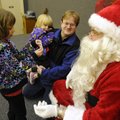 JOLLY TIME Lilli Otte, 7, left, talks to Santa on Saturday as Ali Otte, 3, stays safely with father,...