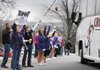 PURPLE’DOG SEND-OFF Susie Baker holds a sign and Grayson Coats waves a pole with a tiger at the end of a string Friday while they stand with others to cheer Fayetteville High School’s Bulldogs as they leave for Little Rock at the high school. The team plays Bentonville High School’s Tigers for the 7A championship at noon today in War Memorial Stadium. For a related report previewing the game, turn to sports, 6A.
