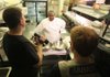 
Jason Shivers (right) and Gregory Wagnon (left) of Aristotle talk with chef Evette Brady of Restaurant 1620 in Little Rock Tuesday afternoon while shooting a video. Since the demise of dial-up internet service, Aristotle has turned to doing web design and video production for customers. 
