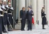 French President Nicolas Sarkozy welcomes German Chancellor Angela Merkel as they prepare to discuss Europe’s financial crisis at Elysee Palace in Paris on Monday. 