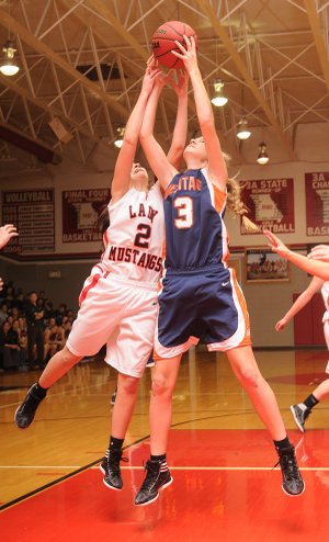 Ellen Lundy, Heritage Lady War Eagles guard, right, competes for a rebound with the Lady Mustangs’ Kenzie Dill on Tuesday at McDonald County High School in Anderson, Mo.