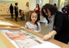 MIRACLE OF ART Eve Rosin, guided tour coordinator with Crystal Bridges Museum of American Art in Bentonville, talks with Miracle Moy, 7, a second-grader from Centerton Gamble Elementary School, as she looks over an interactive display showing the different textures of paintings. The museum announced a $1 million gift from the Jack and Melba Shewmaker Family to benefit hands-on educational programs at the museum.
