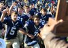 Pulaski Academy players, including Jack Snider (5) and Fredi Knighten (7), rush toward the Class 4A state championship trophy Saturday at War Memorial Stadium in Little Rock. Knighten was the MVP in the Bruins’ victory over Malvern. 