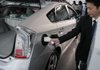 A Toyota Motor Corps employee demonstrates how to charge the Prius hybrid plug-in, the Prius PHV, in Tokyo. 