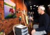 Michael Gory, right, a veterinarian with a Masters Degree in Fine Arts works on one of his paintings of cows at the Majesty Republic gallery on the square in Bentonville, Ark. Tuesday, Dec. 13, 2011. 