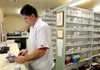 Jon Ragan, pharmacist at HealthMart Pharmacy, fills a prescription at the business Tuesday in Springdale. Rules are changing with users who have Express Scripts as a benefit manager, which won’t allow Walgreens to be used to fill prescriptions starting in January. Local pharmacies hope to increase their business with the change.
