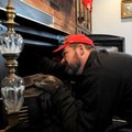 Kevin Mansell inspects and cleans the fire box of a wood stove in a Springdale home on Wednesday.
