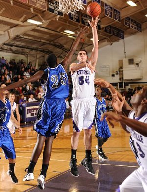 STAFF PHOTO ANDY SHUPE -- Fayetteville junior Tyler McCullough (54) reaches to score over Oklahoma City (Okla.) Southeast's Rashawn Thomas Friday, Dec. 16, 2011, during the first half of play at Fayetteville High. Go to nwaonline.com/photoreprints to see more photos.