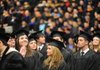 TRADITION RESUMES Chelsea Burns of Bentonville waves to family Saturday in Barnhill Arena during the University of Arkansas’ first fall commencement since 1971.

