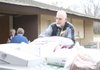 Jim Snyder unloads food at Grace United Methodist Church. At left is coordinator Ella McGee.
