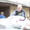 Jim Snyder unloads food at Grace United Methodist Church. At left is coordinator Ella McGee.
