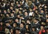 Arkansas Democrat-Gazette/MICHAEL WOODS --12/17/2011-- University of Arkansas graduates listen to the guest speakers as they await their degrees during the Fall University of Arkansas commencement ceremony Saturday morning at Barnhill Arena in Fayetteville.  The first U of A Fall commencement in 40 years was held Saturday with about 700 graduates receiving their degrees.