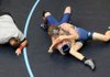 Garrett Comer of Springdale Har-Ber High, top, tries to pin Collin Condit of Conway on Thursday at Har-Ber High School’s Wildcat Arena in Springdale.