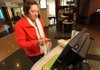 Julia Woodward, a teacher at Ramay Junior High School in Fayetteville, uses a self-checkout station Friday for a stack of books at the Fayetteville Public Library.