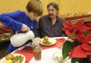 Jack Walker Pool, 8, pours coffee for Jerry Letterman, of Prairie Creek, during the annual Community Christmas Dinner at Central United Methodist Church in Rogers. The church expected to serve 200 people and deliver another 200 meals to people in the area.