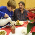Jack Walker Pool, 8, pours coffee for Jerry Letterman, of Prairie Creek, during the annual Community...
