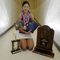 Tiffany Tang holds some of the trophies she has won playing tennis for Rogers High School.