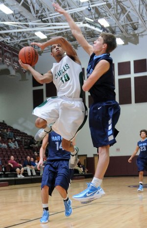 Ehron Ponds, left, of Edison Prepatory School tries to make a shot over the arm of Springdale Har-Ber’s Alex Rice on Wedesday at the Siloam Springs Holiday Invitational at Siloam Springs.