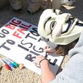 STAFF PHOTO J.S. WEDGEWORTH
Dylan Stewart, of Gravette, wears a Guy Fawkes mask while making a prot...
