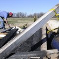 John Thomas with the Rogers Public School Maintenance Department cleans up the charred remains of th...