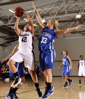 Karen Perez, Springdale High, left, takes the ball to the basket Friday under pressure from Carthage’s Chloe Shepherd during the Lady Bulldog’s game against the Lady Tigers at the Neosho Holiday Classic in Neosho, Mo.
