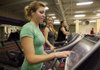 Arkansas Democrat-Gazette/RYAN MCGEENEY --12-21-11-- Jennie Clark of Fayetteville, left, interacts with her iPod MP3 player through the console of a treadmill at the Fayetteville Athletic Club as her friend Sarah Dodd, also of Fayetteville, right, watches. The club recently added new exercise equipment which facilitates the use of electronic games, web browsing, and the use of iPods and other electronic devices.