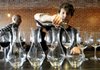 Andrew Futch practices pouring water from a decanter into a wine glass Thursday as part of the wine serving training for employees at the Pressroom in downtown Bentonville.
