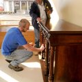 Hunter Collins, left, and Bill Schopp polish a piece of 100-plus-year-old furniture after moving it ...