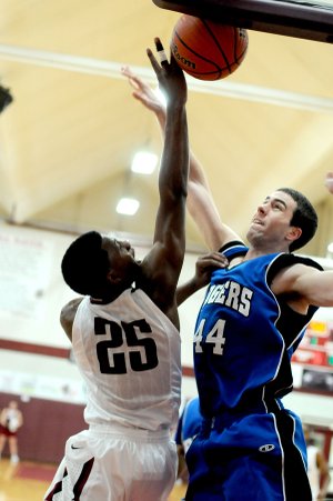 Nathan Musso, Rogers High senior, defends against Springdale High sophomore D.J. Evans in the first half on Friday at Bulldog Gym in Springdale.
